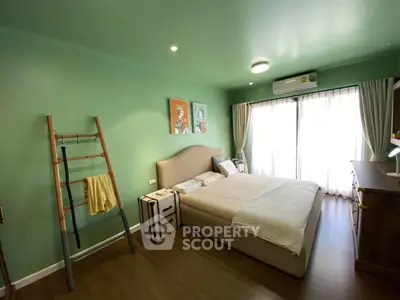 Spacious bedroom with modern decor and large window for natural light