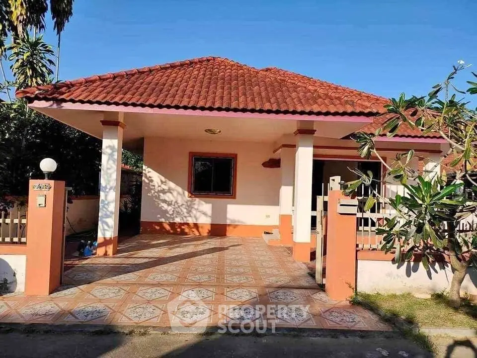 Charming single-story house with tiled roof and spacious front patio.