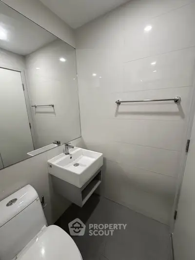 Modern minimalist bathroom with sleek fixtures and large mirror