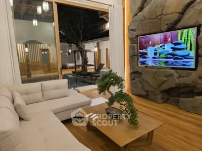 Luxurious living room with modern decor and pool view, featuring a large TV and elegant furniture.