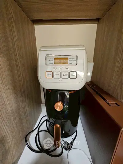 Modern kitchen appliance in sleek wooden cabinet, showcasing compact design and functionality.