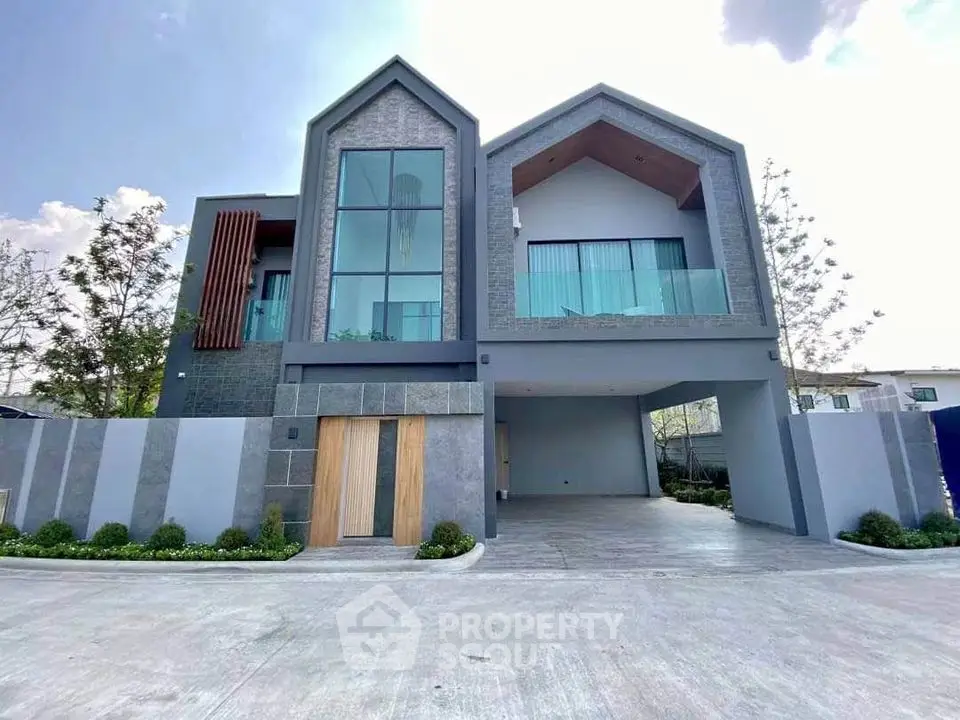 Modern two-story house with large windows and spacious driveway