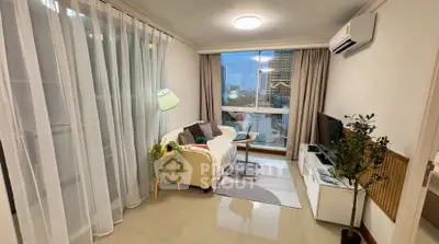 Cozy living room with modern decor and large window offering city views.