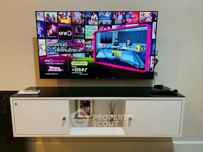 Modern living room with wall-mounted TV and sleek white cabinet