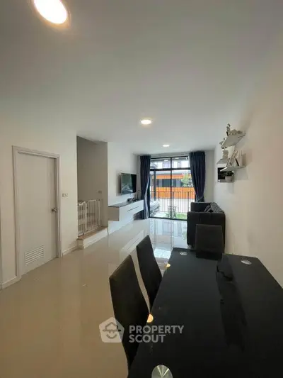 Modern living room with sleek furniture and large windows for natural light.