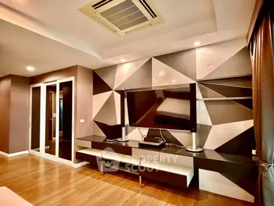 Modern living room with geometric wall design and large TV unit