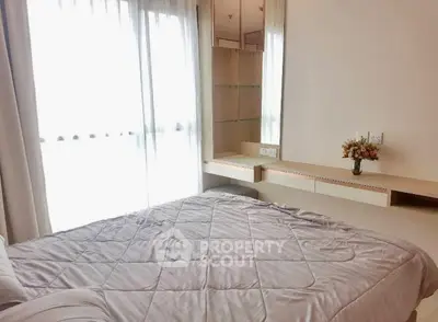 Bright and cozy bedroom with large window and modern furnishings, perfect for relaxation.