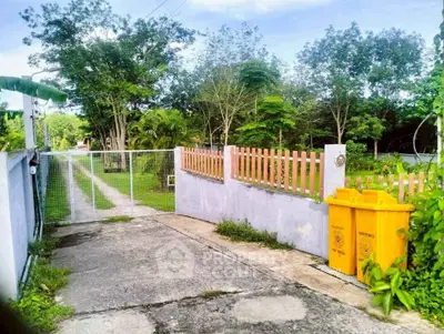 Charming gated entrance with lush greenery and spacious driveway