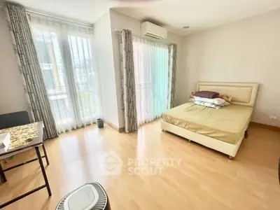 Bright bedroom with large windows and modern furnishings