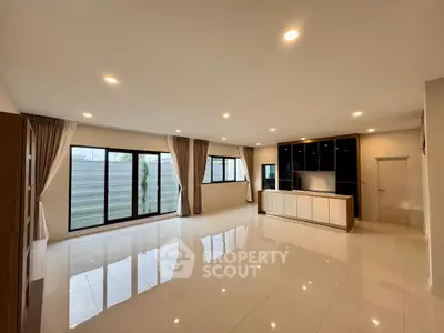 Spacious modern living room with large windows and sleek tile flooring