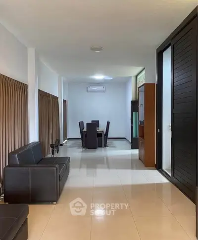 Spacious living room with modern furniture and sleek design, perfect for comfortable living.