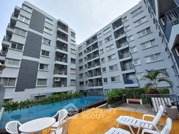 Modern apartment complex with pool and outdoor seating area