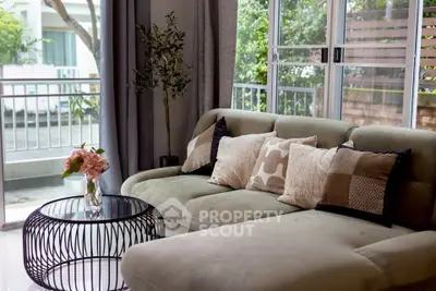 Chic living room with plush sofa, stylish coffee table, and large windows offering serene outdoor views.