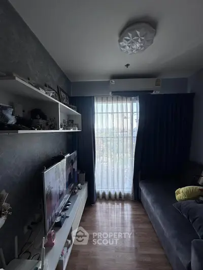 Cozy living room with modern decor and natural light through large window.