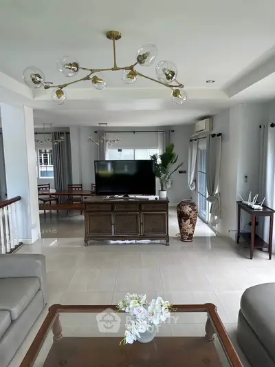 Spacious living room with elegant decor and modern lighting in a luxurious home.