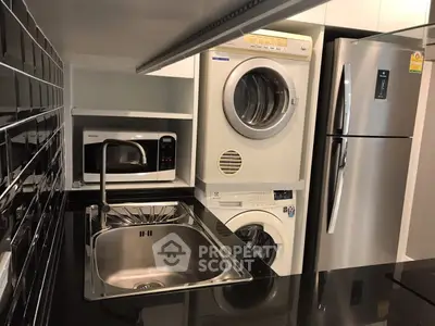 Modern kitchen with sleek appliances including fridge, microwave, and washer-dryer combo.