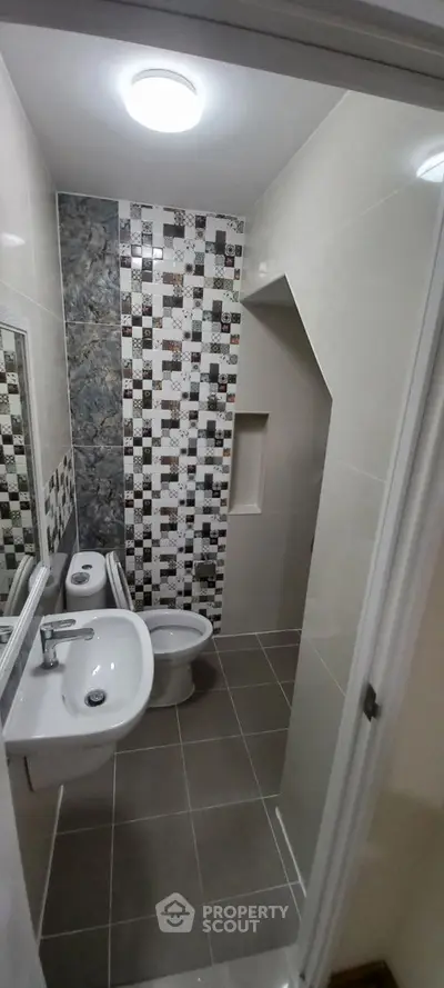 Modern bathroom with stylish tile design and compact layout