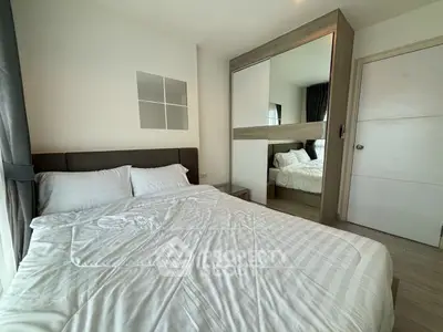 Modern bedroom with mirrored wardrobe and cozy bedding in a stylish apartment.