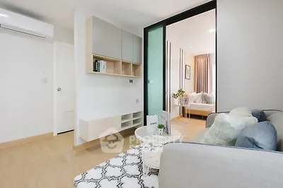 Modern living room with stylish decor and open layout leading to bedroom.