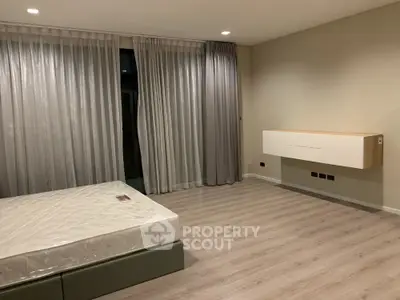 Spacious modern bedroom with large windows and elegant flooring in a stylish apartment.