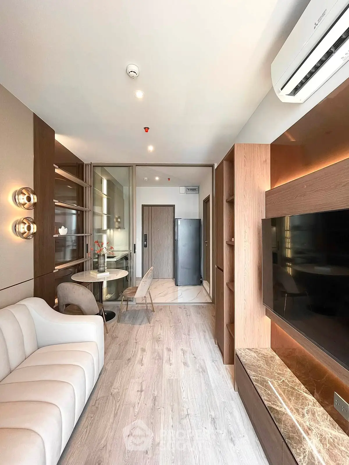 Modern living room with elegant decor and open layout, featuring a cozy sofa and sleek dining area.
