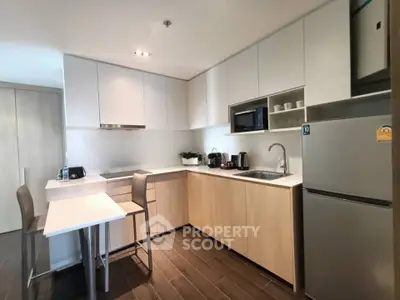 Modern kitchen with sleek cabinetry and integrated appliances in a stylish apartment.