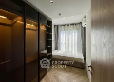 Modern bedroom with large window and sleek wardrobe in a stylish apartment.