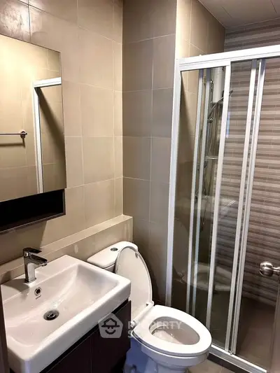 Modern bathroom with sleek shower and stylish sink in contemporary apartment.