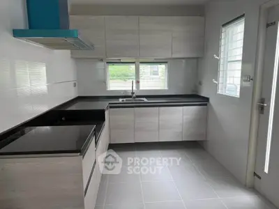 Modern kitchen with sleek cabinetry and large windows for natural light.