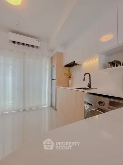 Modern kitchen with sleek design, featuring built-in appliances and ample natural light.