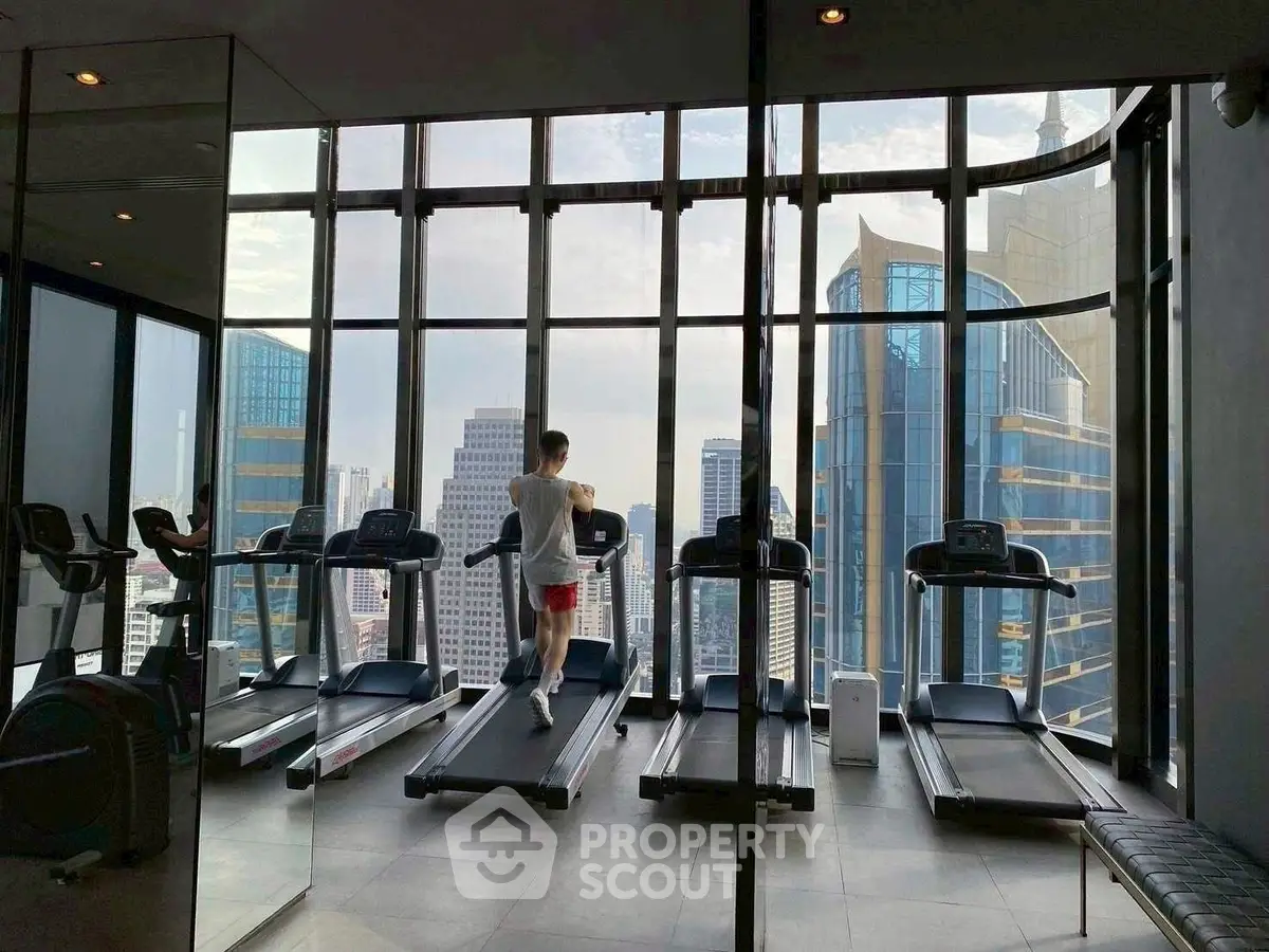 Luxurious high-rise gym with panoramic city views and modern equipment.