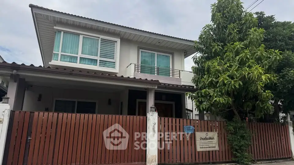 Charming two-story house with modern design and lush greenery, perfect for family living.