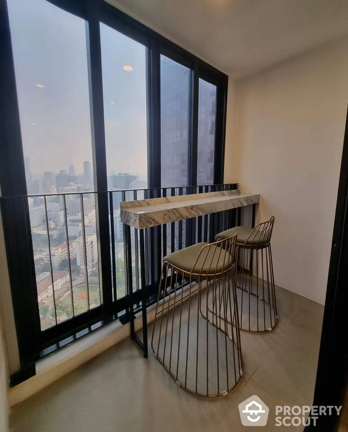 Modern balcony with city view, stylish bar stools, and sleek design for urban living.