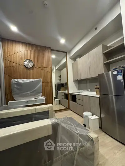Modern kitchen with sleek cabinetry and stainless steel appliances in a stylish apartment.