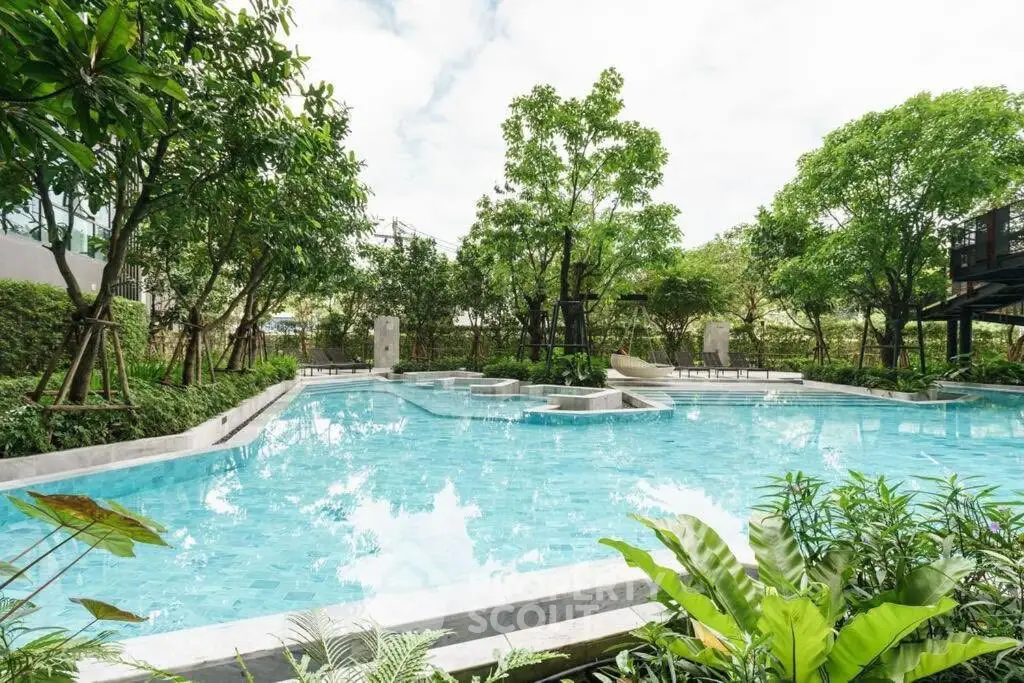 Luxurious outdoor pool surrounded by lush greenery in a serene residential setting.