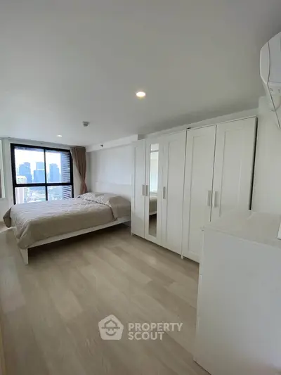Spacious bedroom with city view, featuring modern wardrobe and cozy bed in a high-rise apartment.