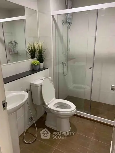 Modern bathroom with glass shower enclosure and sleek fixtures.
