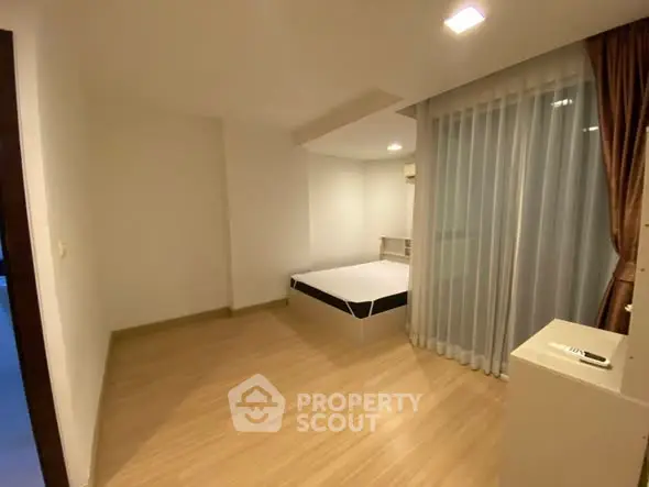 Spacious bedroom with modern design and large window for natural light.