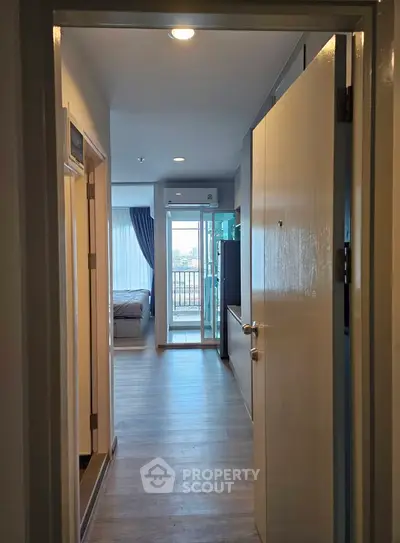 Modern apartment entrance leading to a bright living area with balcony view.