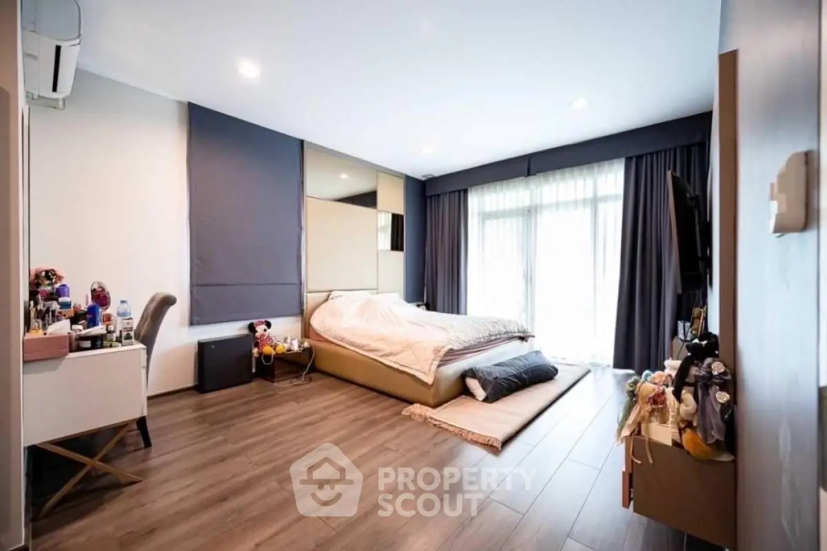 Spacious modern bedroom with elegant decor and large windows for natural light.