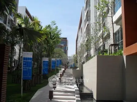 Modern apartment complex with lush greenery and clear blue sky