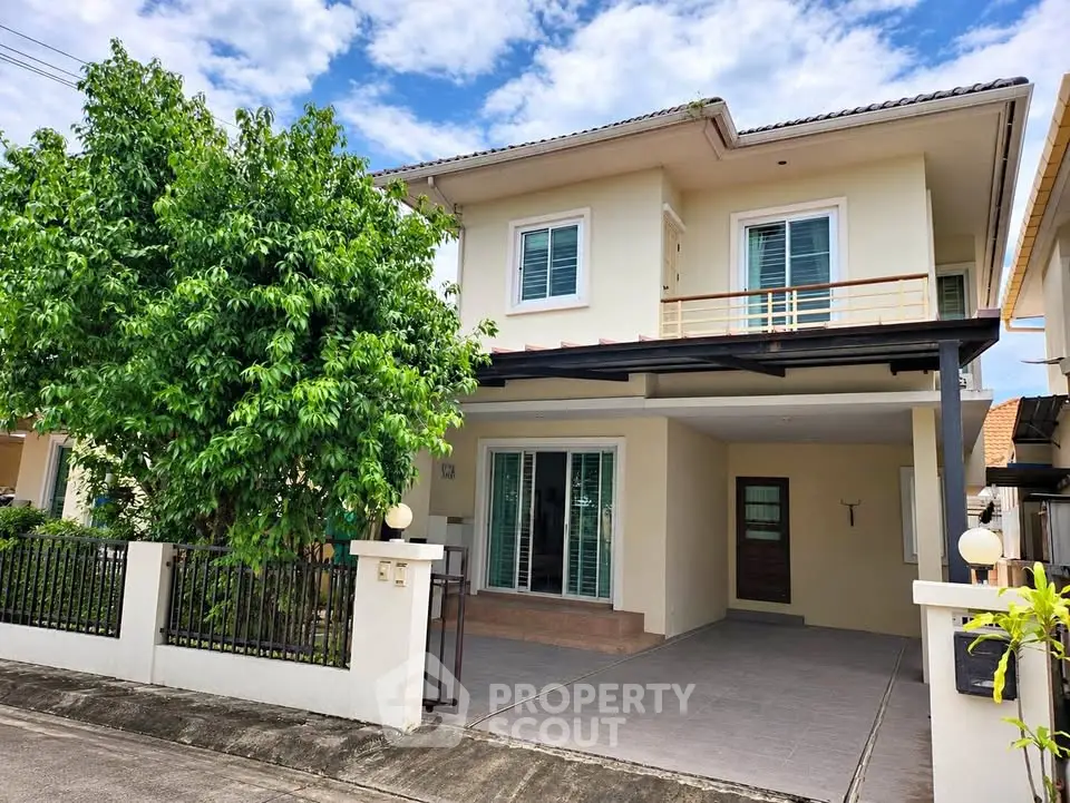 Charming two-story house with spacious driveway and lush greenery, perfect for family living.
