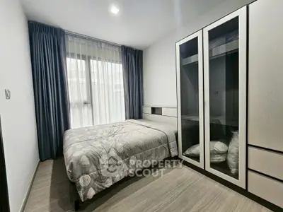 Modern bedroom with large window and stylish wardrobe in a cozy apartment.