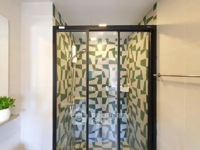 Modern bathroom with stylish geometric tile shower and glass door enclosure.