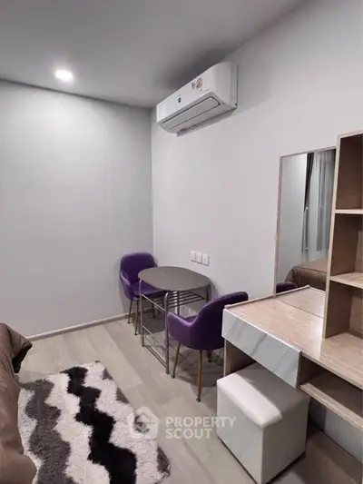 Modern compact living space with stylish furniture and air conditioning, perfect for urban living.