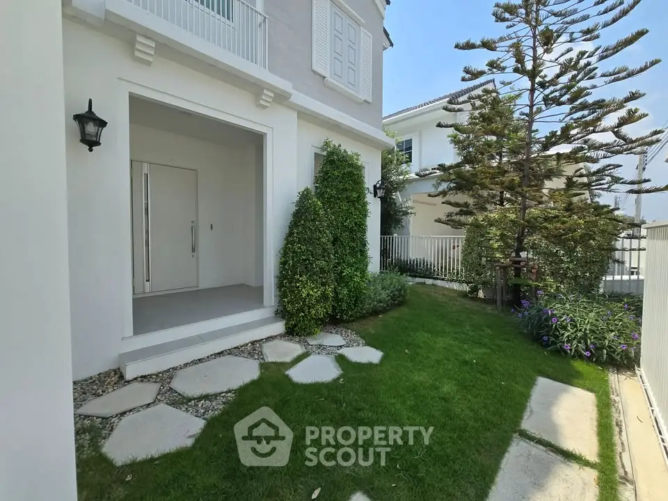 Charming exterior view of a modern home with lush garden and elegant entrance.