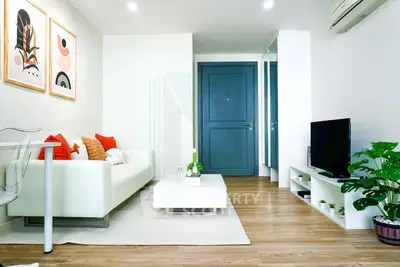 Modern living room with stylish decor, white sofa, and wooden flooring in a bright apartment.