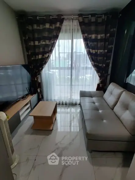 Modern living room with sleek sofa, marble flooring, and large window with elegant curtains.