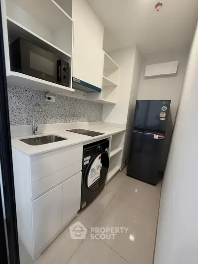 Modern kitchen with sleek appliances and stylish cabinetry in a compact layout.