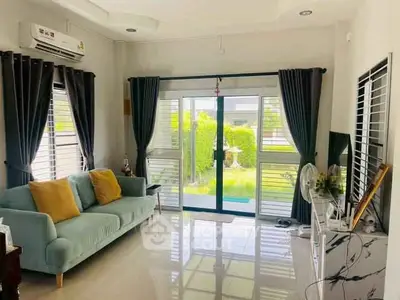 Bright living room with modern decor and garden view, featuring a cozy sofa and sleek entertainment unit.